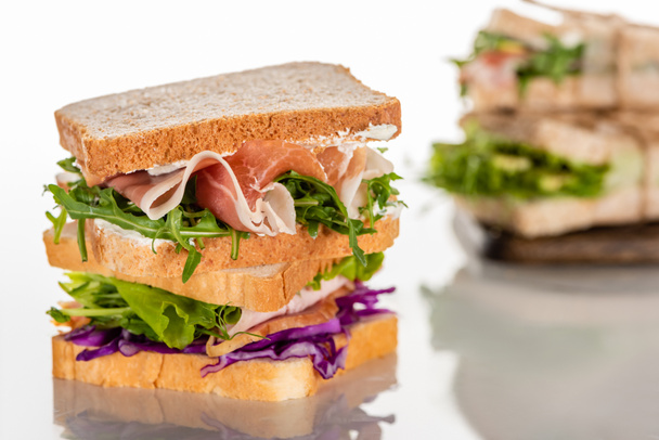 selective focus of fresh sandwiches with arugula and meat on white surface  - Foto, immagini