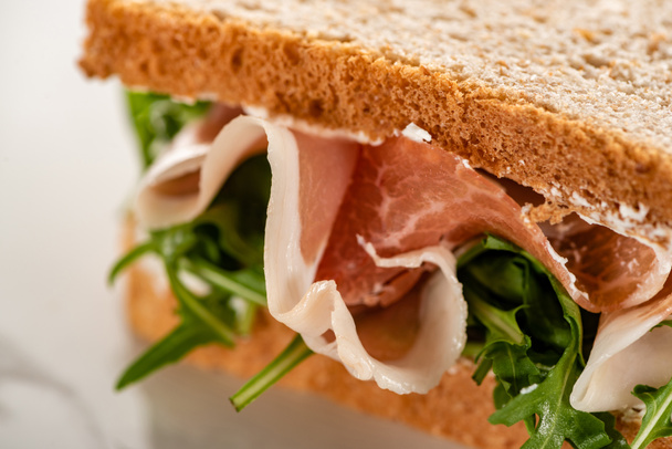 close up view of fresh sandwich with arugula and prosciutto - Foto, Imagem