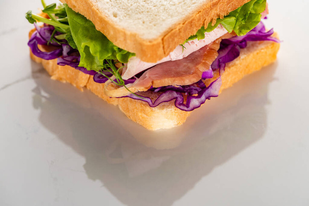 close up view of fresh green sandwich with meat on marble white surface - Photo, Image