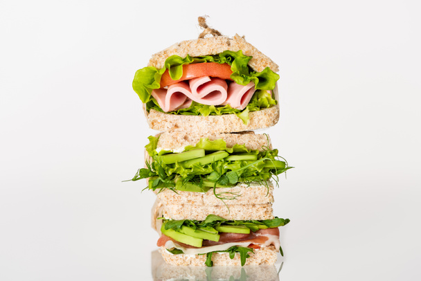 φρέσκα πράσινα σάντουιτς με αβοκάντο και κρέας σε λευκή επιφάνεια - Φωτογραφία, εικόνα