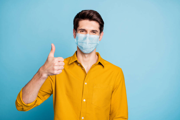 Close-up portrait of his he nice confident healthy guy wearing safety mask showing thumbup mers cov flu grippe prevention health care isolated pastel color background - Foto, immagini