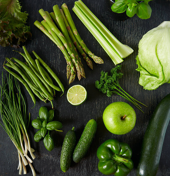 green vegetables and herbs on black chalkboard - 写真・画像
