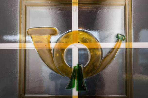 graphical symbol of a yellow glass post horn on a window - Photo, Image
