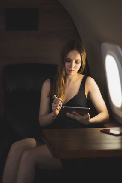 Attractive woman in private jet - Φωτογραφία, εικόνα