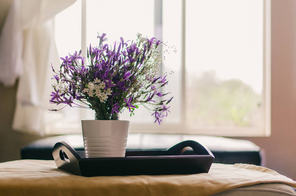 Un bouquet de fleurs sauvages à l'intérieur d'une pièce aérée ; les fenêtres sont ouvertes pour laisser entrer la brise printanière. - Photo, image