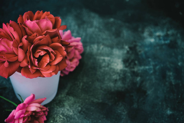 Roze rozen op stemmige textuur achtergrond met kopieerruimte - Foto, afbeelding