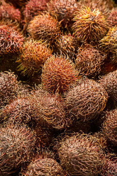A full frame photograph of rambutan fruit for sale on a market stall - Foto, imagen