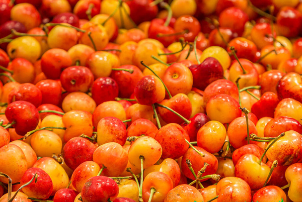 A full frame photograph of juicy cherries for sale on a market stall - Фото, зображення
