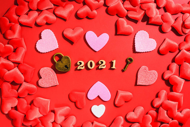 kłódka reprezentuje zaangażowanie miłości pary w 2021 roku, na czerwonym tle z sercami na Walentynki. - Zdjęcie, obraz