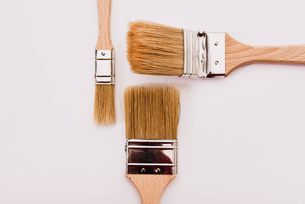 White background with painter brushes for decoration business and home renovations. - Foto, Bild