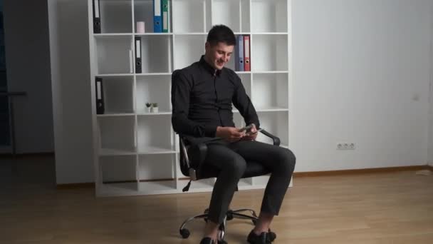 A lawyer in a black shirt sits on a chair in his office with panoramic windows and counts the money earned today - Záběry, video