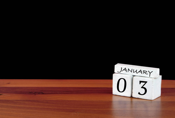 3 January calendar month. 3 days of the month. Reflected calendar on wooden floor with black background - Photo, Image