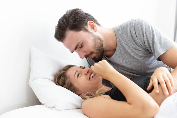 Caucasion couple feeling happy on bed in bedroom - Photo, Image