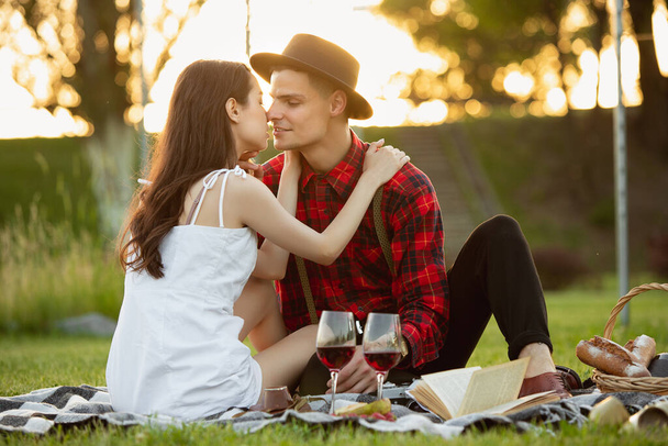 Caucasian young and happy couple enjoying a picnic in the park on summer day - Fotoğraf, Görsel