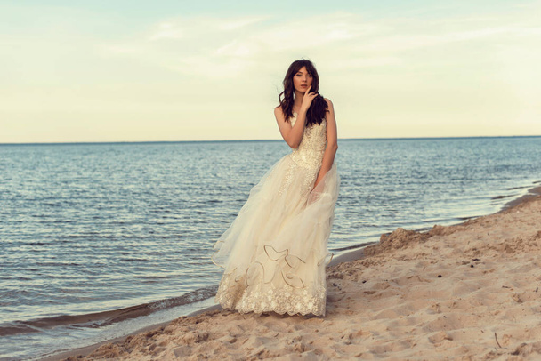 Bride in a white dress by the sea - Фото, изображение