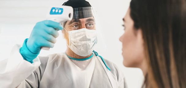 Доктор вимірює температуру з новим цифровим термометром для молодої жінки-пацієнтки під час пандемії коронавірусу концепція охорони здоров'я та медичного обладнання
 - Фото, зображення