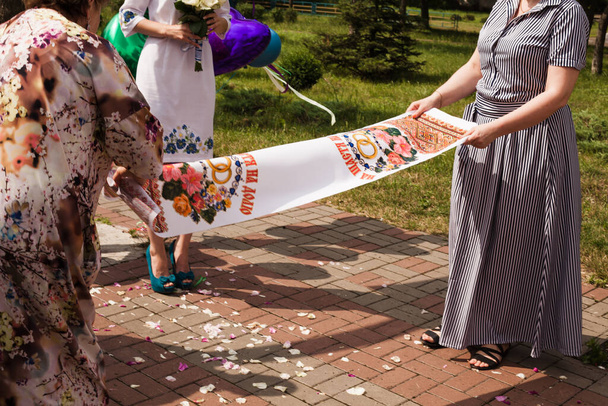 Ukrainian wedding. Two mothers are laying a Ukrainian rushnyk. - Photo, Image