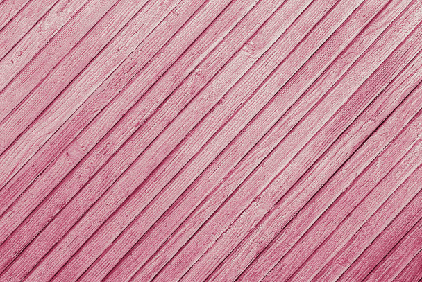 pink abstract background of diagonally arranged old wooden planks with cracked paint texture - Fotó, kép