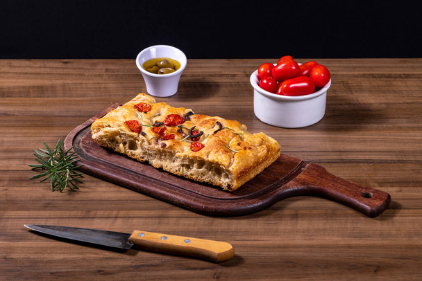 Traditional Italian Focaccia with cherry tomatoes, black olives and rosemary. - Photo, Image