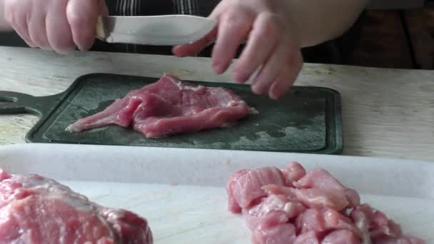 o cozinheiro corta a carne de porco em pedaços
 - Filmagem, Vídeo