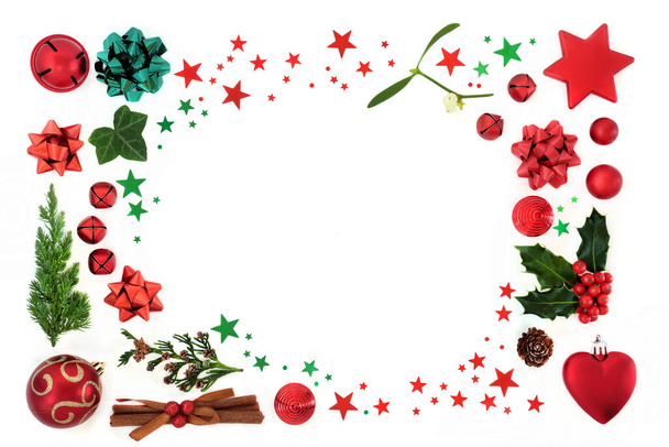 Kerst achtergrond border decoratie met rode kerstballen, sterren, hulst, spar, ceder & klimop op wit. Decoratieve kerstcompositie voor de feestdagen. Bovenaanzicht, flat lay, kopieerruimte. - Foto, afbeelding