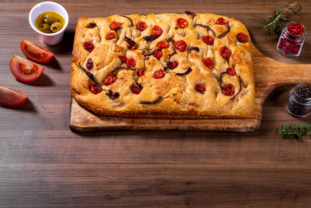 Traditional Italian Focaccia with cherry tomatoes, black olives and rosemary - Foto, afbeelding