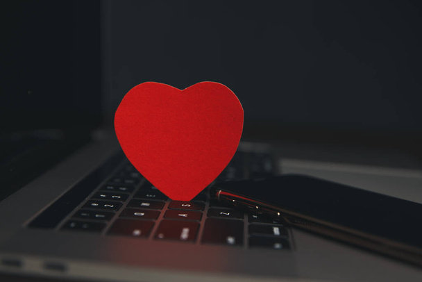 Computadora con corazones rojos en la mesa de cerca
 - Foto, Imagen