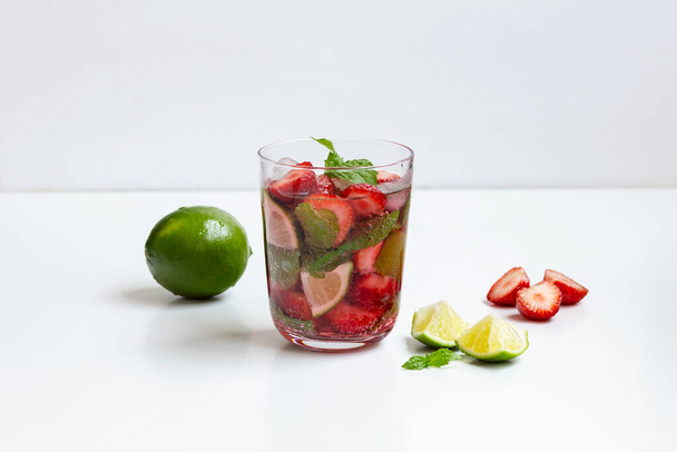 Πιείτε λάιμ, μέντα και φράουλα σε ένα ποτήρι στο τραπέζι - Φωτογραφία, εικόνα