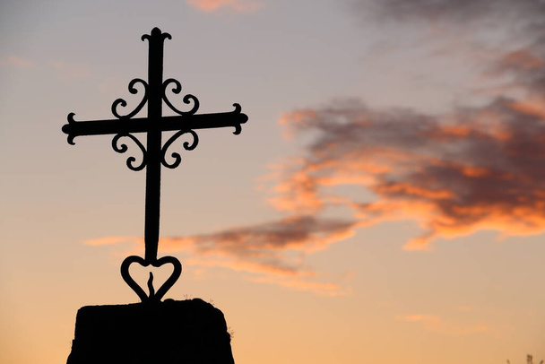 IJzer gemaakt christelijk kruis buiten. Zonsondergang hemel achtergrond. - Foto, afbeelding
