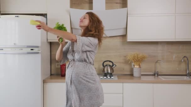 美しい妊娠中の女性は台所で野菜と食事を準備し、踊る. - 映像、動画
