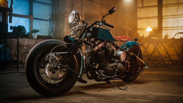 Custom Bobber Motorbike Standing in an Authentic Creative Workshop. Vintage Style Motorcycle Under Warm Lamp Light in a Garage. - Photo, Image