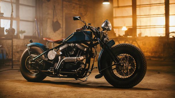 Custom Bobber Motorbike Standing in an Authentic Creative Workshop. Vintage Style Motorcycle Under Warm Lamp Light in a Garage. - Foto, immagini