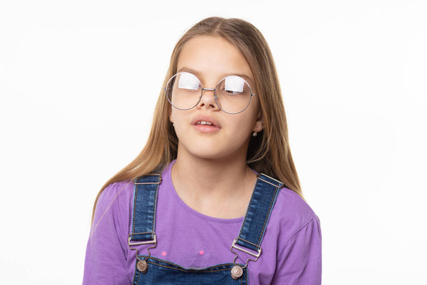 Porträt eines Mädchens mit greller Brille, das versucht, auf ihre Nase zu schauen - Foto, Bild