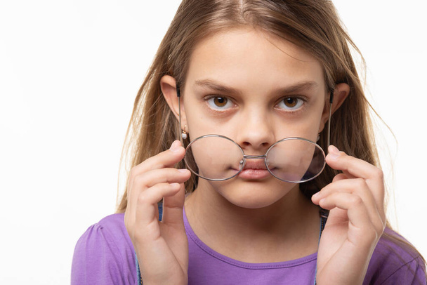 nastolatka dziewczyna zdejmuje okulary, zbliżenie - Zdjęcie, obraz