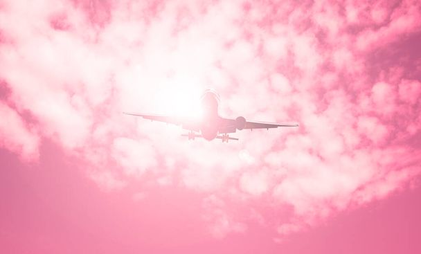 Avião contra um céu vermelho e o sol é brilhante
 - Foto, Imagem