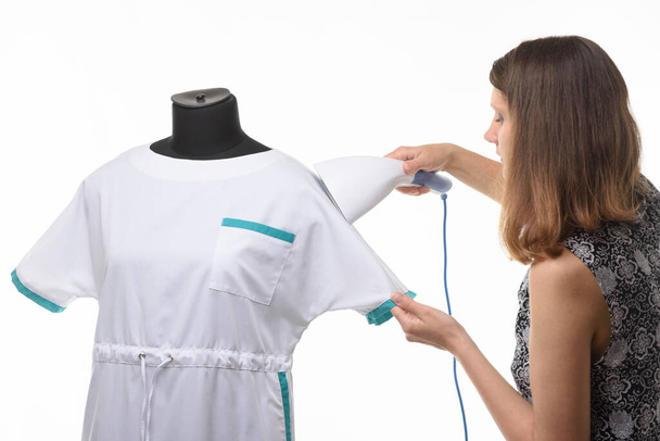 Girl seamstress steals a medical gown before issuing to a client - Foto, Imagem