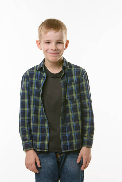Portret van een lachende jongeman van tien jaar op een witte achtergrond - Foto, afbeelding