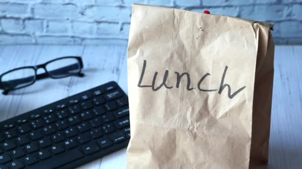 Paper lunch bag on office desk, close up. - Footage, Video