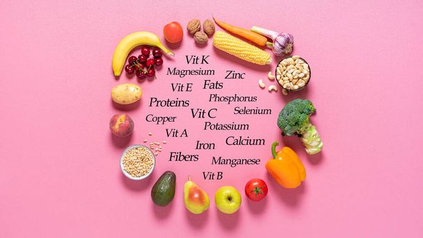 Fresh fruits and vegetables and their nutrition facts, on a pink background. Vegan food is rich in minerals, proteins, fats, and vitamins. - Photo, Image