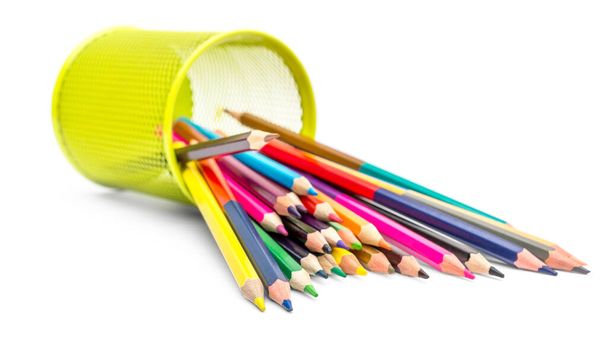 Kolorowe ołówki rozrzucone z metalowego uchwytu na białym tle. - Zdjęcie, obraz