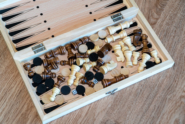 Šachy a šachy jsou náhodně smíchané roztroušené v dřevěné krabici. - Fotografie, Obrázek