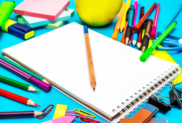 Notepad with school supplies on blue.  - 写真・画像