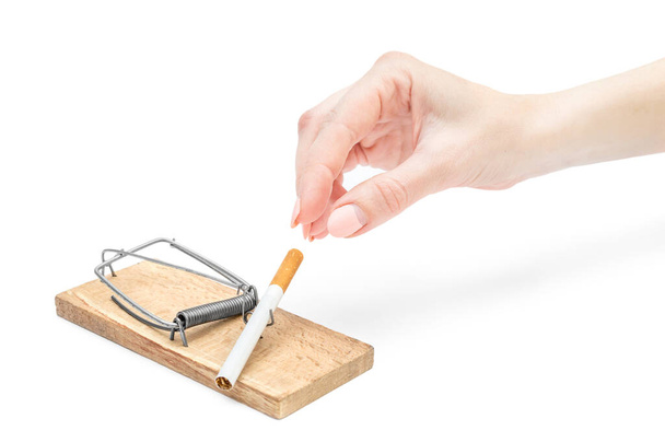 Woman's hand taking cigarette from mousetrap on white background. - Photo, Image