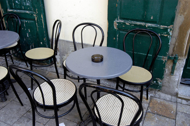 jardín de cerveza vacío con mesas, sillas y un cenicero vacío
 - Foto, Imagen