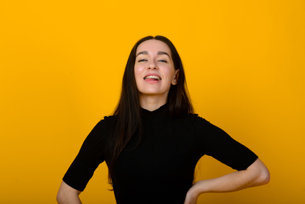 Wow. Beautiful female half-length front portrait isolated on yellow studio backgroud. Young emotional surprised woman standing with open mouth. Human emotions, facial expression concept. - Foto, imagen
