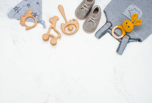 Pasgeboren baby kleding en zitzakken op marmeren achtergrond met kopieerruimte - Foto, afbeelding