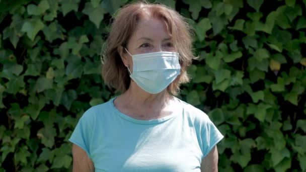 Reife Frau trägt schützende Gesichtsmaske - Filmmaterial, Video