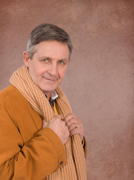 Attraktiver älterer Mann elegant in Pullover-Jacke und Schal gekleidet - Foto, Bild