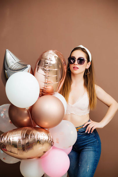 holidays and fashion concept - happy young woman or teenage girl with helium balloons - Foto, Imagem