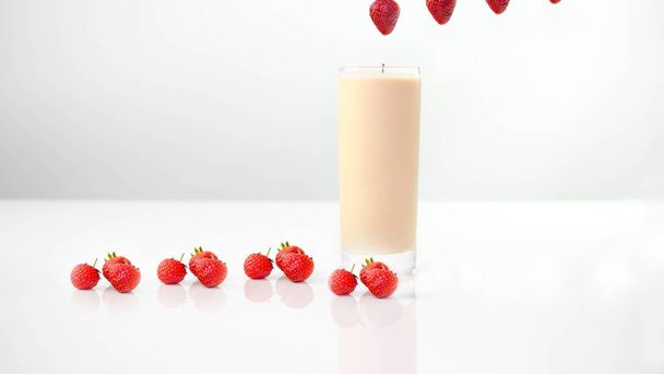 Yogurt in a glass and a lot of ripe strawberries,on a white background. - Foto, immagini